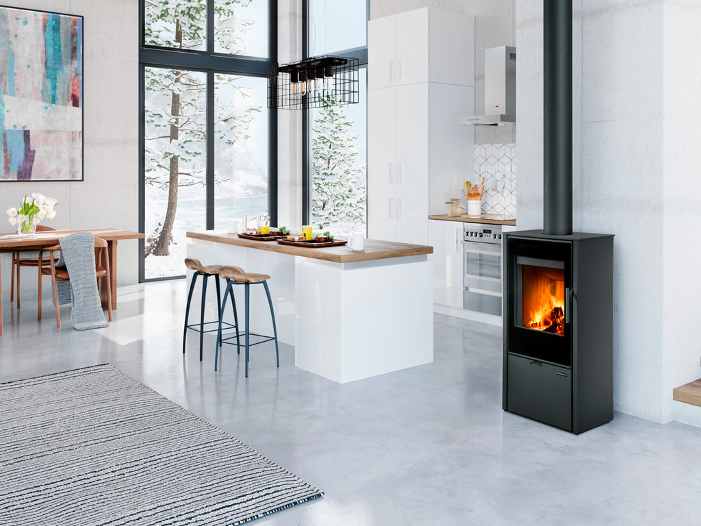 Soba pe lemne moderna din otel Laredo F30 intr-o bucatarie open space luminoasa cu design scandinav, fereastra mare si vedere spre peisaj de iarna cu zapada.