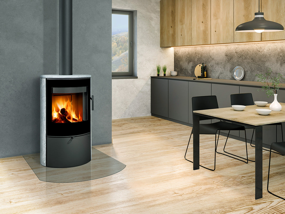 Soba piatra Ovalis G montata intr-un living open-space, langa bucatarie