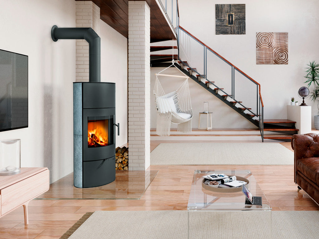 Soba pe lemne moderna cilindrica cu foc vizibil si cos lateral, amplasata intr-un living contemporan cu scara interioara si design minimalist elegant.