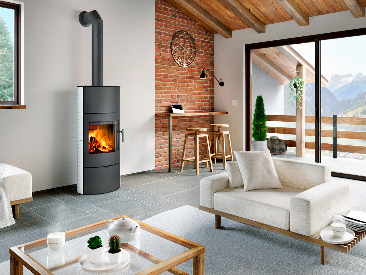 Soba pe lemne moderna cilindrica cu geam frontal si foc vizibil, instalata intr-un living rustic contemporan cu perete din caramida si tavan din lemn.