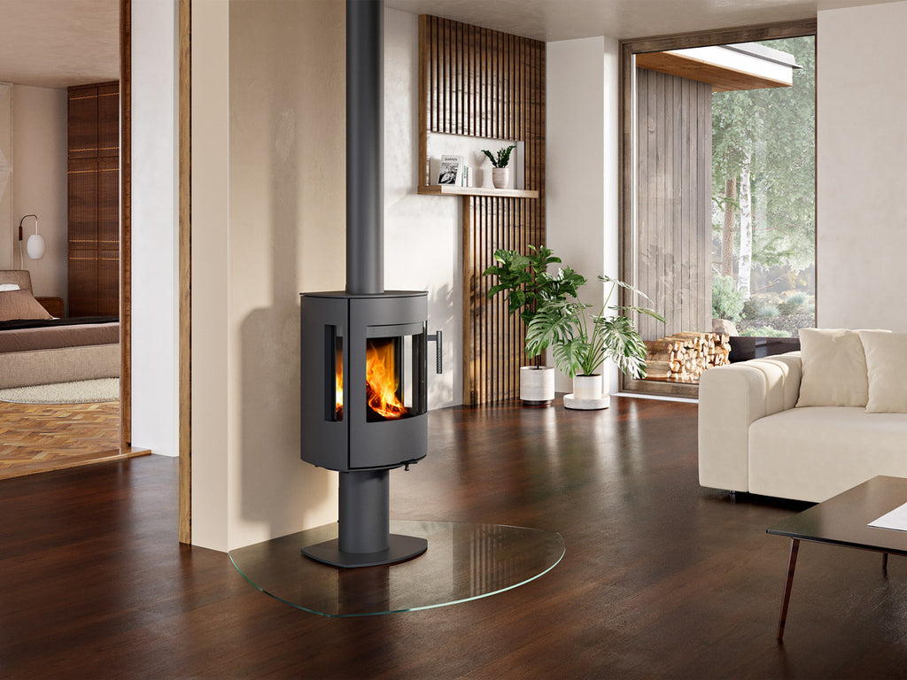 Soba lemne SEIDO T, design modern, metal antracit, cu geamuri laterale, foc vizibil si baza de sticla. Amplasata intr-un living spatios, stil minimalist.