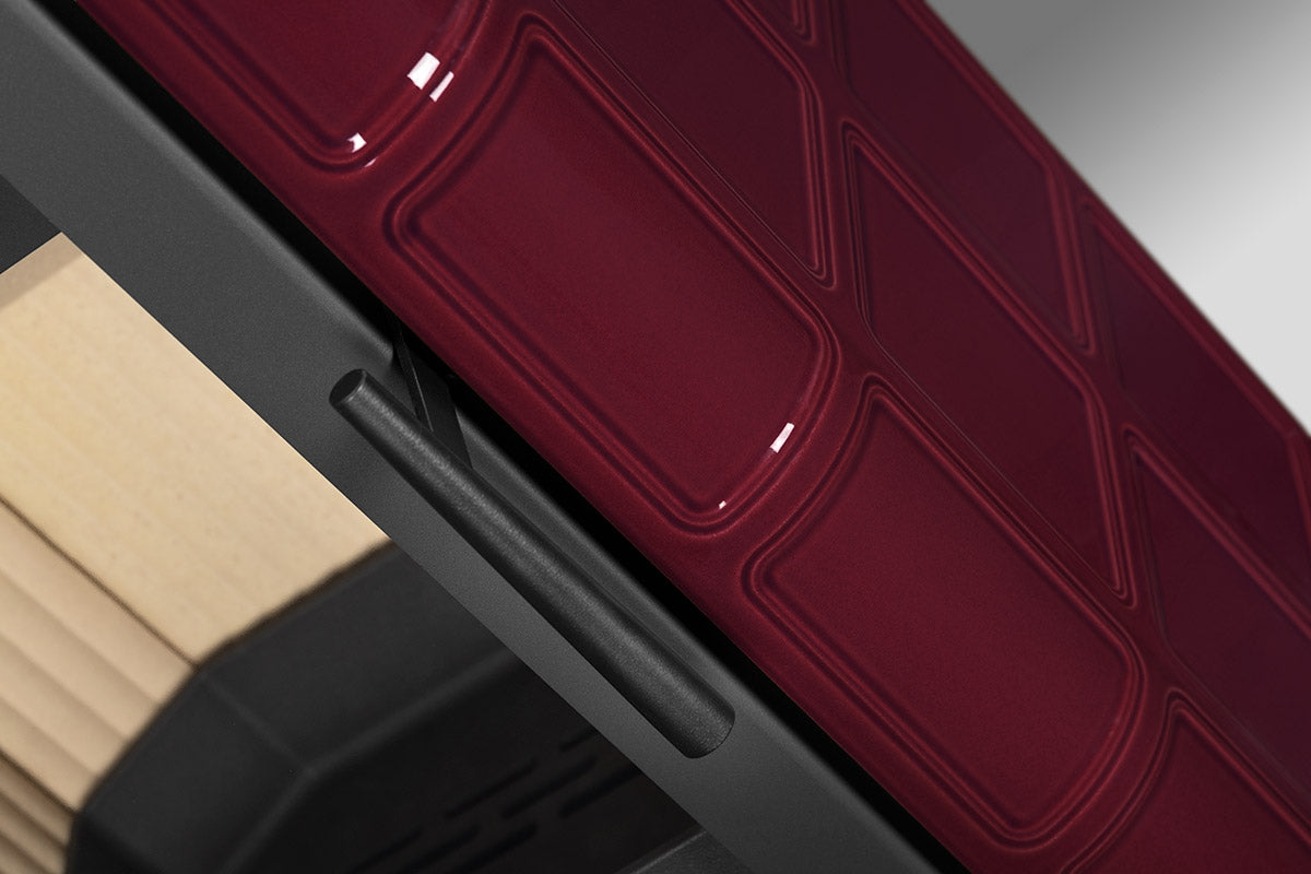 Soba lemne SIENA, cu panou lateral ceramic visiniu lucios, cu modele rectangulare. Cadru metalic negru, maner cilindric si spatiu depozitare lemne.