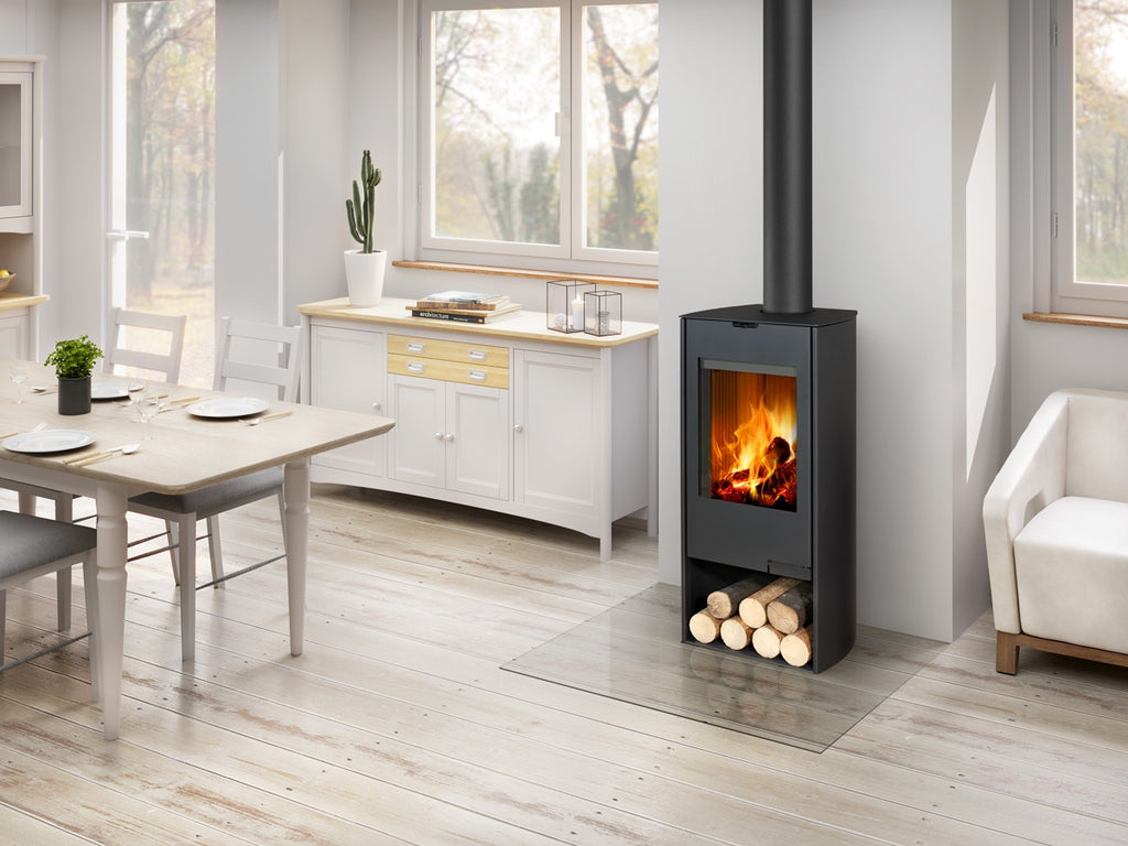 Soba lemne TALA N 06, neagra, metalica, verticala. Geam frontal mare cu foc vizibil, compartiment inferior lemne. Amplasata in living modern.